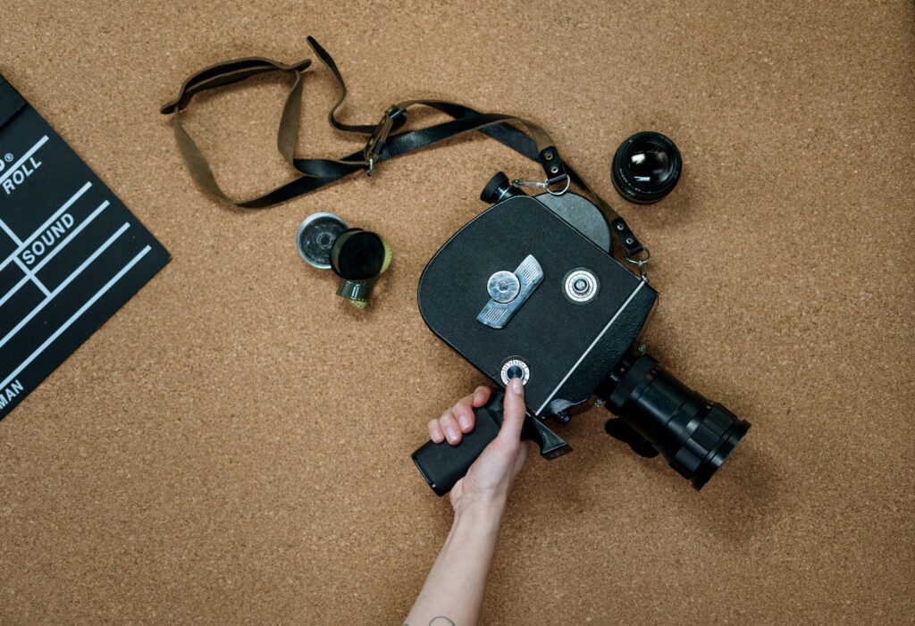 Flat lay of a vintage film camera alongside a clapboard on a cork surface, ideal for cinematic themes.
