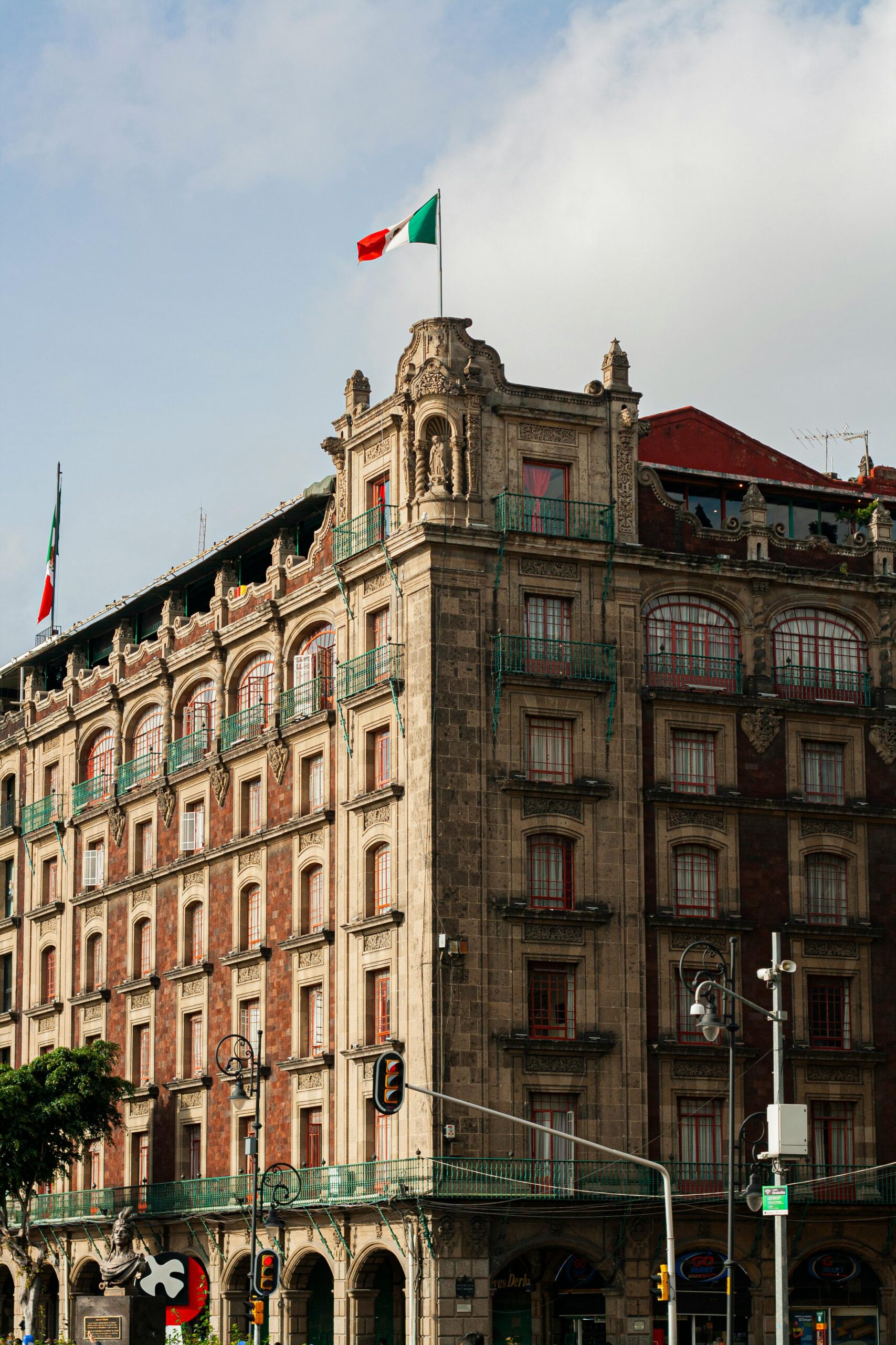 View of a historic building adorned with a Mexican flag in Mexico City, showcasing beautiful architecture.